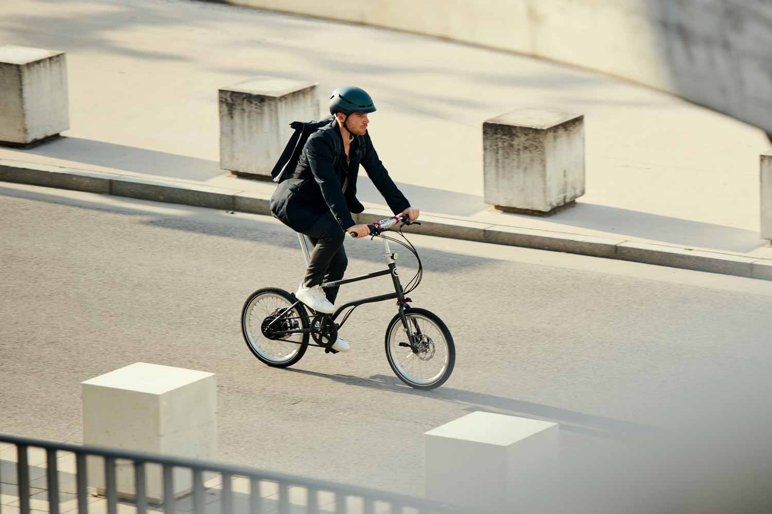 Ein Mann fahrt die Straße entlang auf seinem VELLO 3x3 Nine Edition Faltrad / Klapprad.