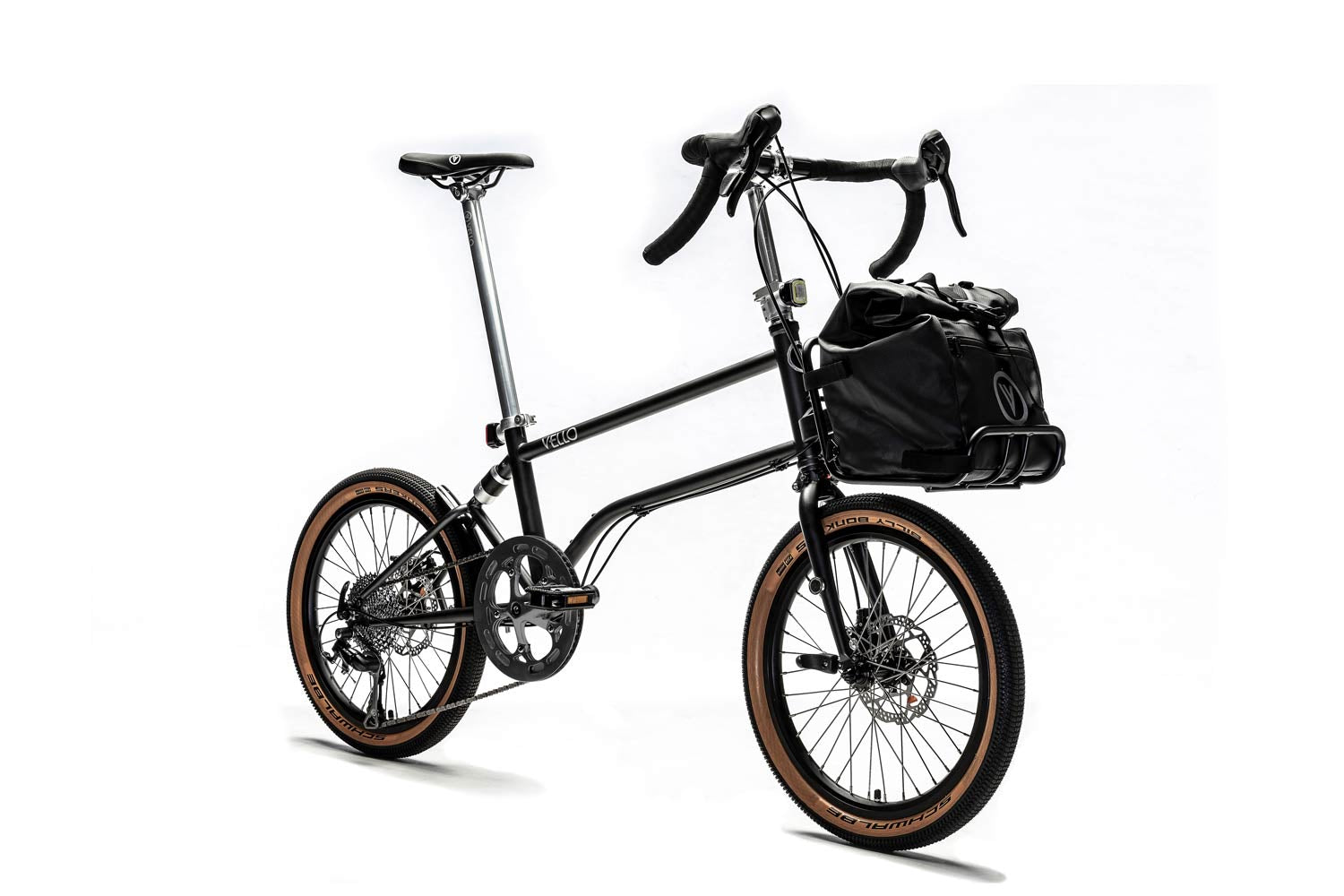 Ein entfaltetes VELLO Gravel Faltrad / Klapprad in der Farbe Anthrazit, mit 20 Zoll Billy Bonkers Reifen mit einem Frontgepäckträger in dem eine VELLO Daypack Tasche ruht.