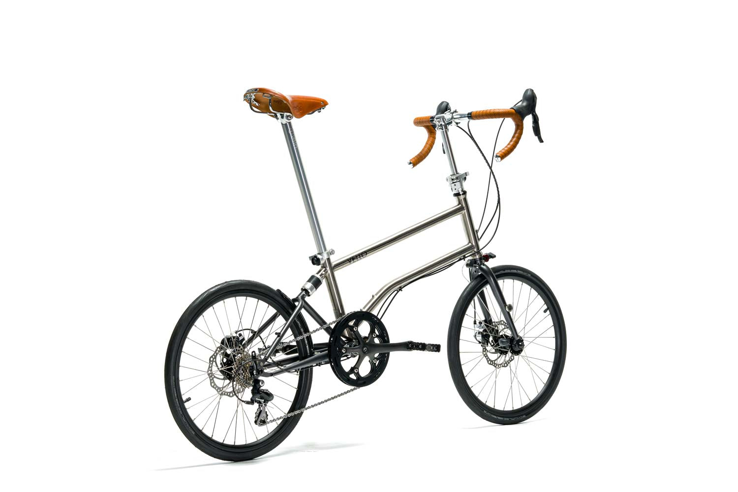 Ein entfaltetes VELLO Speedster Titan Faltrad / Klapprad ,in der Farbe gebürstetes Titan, mit 20 Zoll Schwalbe One Tube Type Performance 28-451 Reifen, Fokus ist auf dem Honigbraunen Sattel.