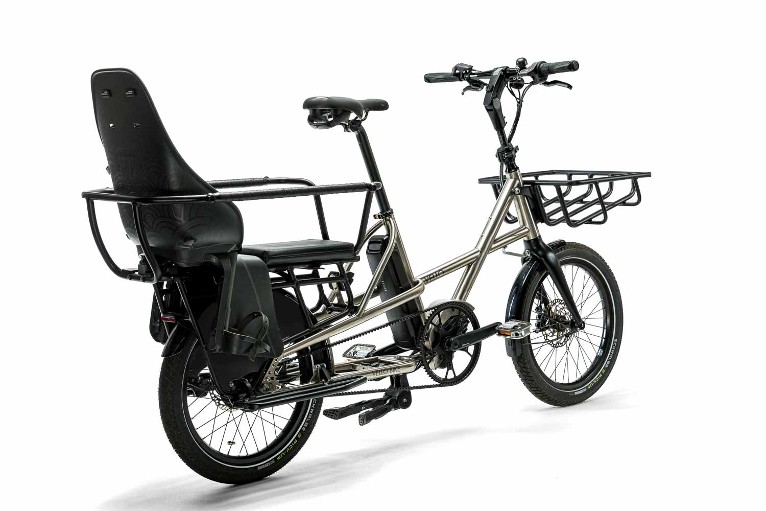Ein VELLO SUB Lastenrad Titan in der Farbe gebürstetes Titan, mit 20 Zoll Schwalbe Pick up Reifen, mit dem Reling, Kindersitz, Falt-Trittbrett, MIK Sitzpolster und Frontgepäckträger.