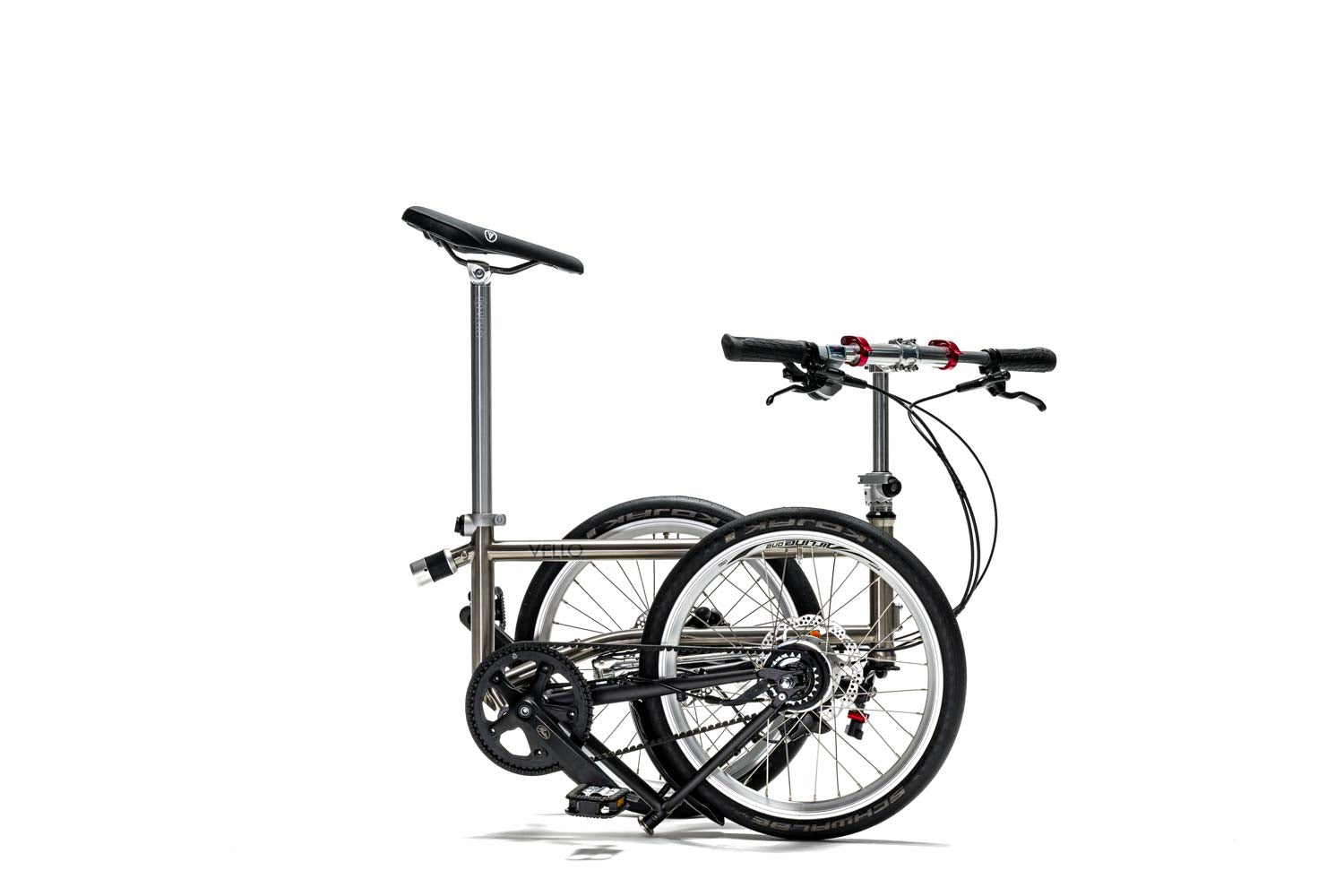 Ein gefaltetes VELLO Alfine Titan Faltrad / Klapprad in der Farbe gebürstetes Titan, mit 20 Zoll Schwalbe Kojak Reifen, mit entfalteten Griffen.
