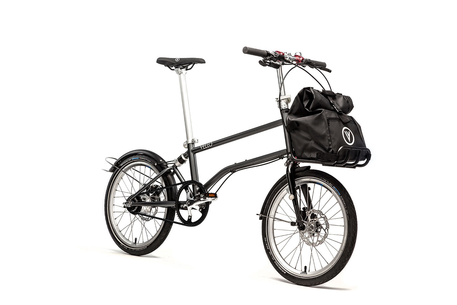 Ein entfaltetes VELLO Alfine Faltrad / Klapprad in der Farbe Anthrazit, mit 20 Zoll Schwalbe Marathon Reifen, der Fokus sitzt auf dem Frontgepäckträger in dem eine VELLO Daypack Tasche ruht.
