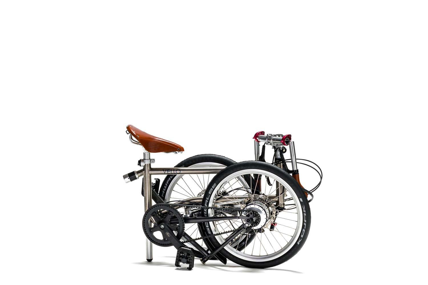 Ein gefaltetes VELLO Rohloff-Special-Edition Titan Faltrad / Klapprad, in der Farbe gebürstetes Titan, mit 20 Zoll Schwalbe Kojak Reifen, mit dem honigbraunen Sattel und faltbaren honigbraunen Lenkern.
