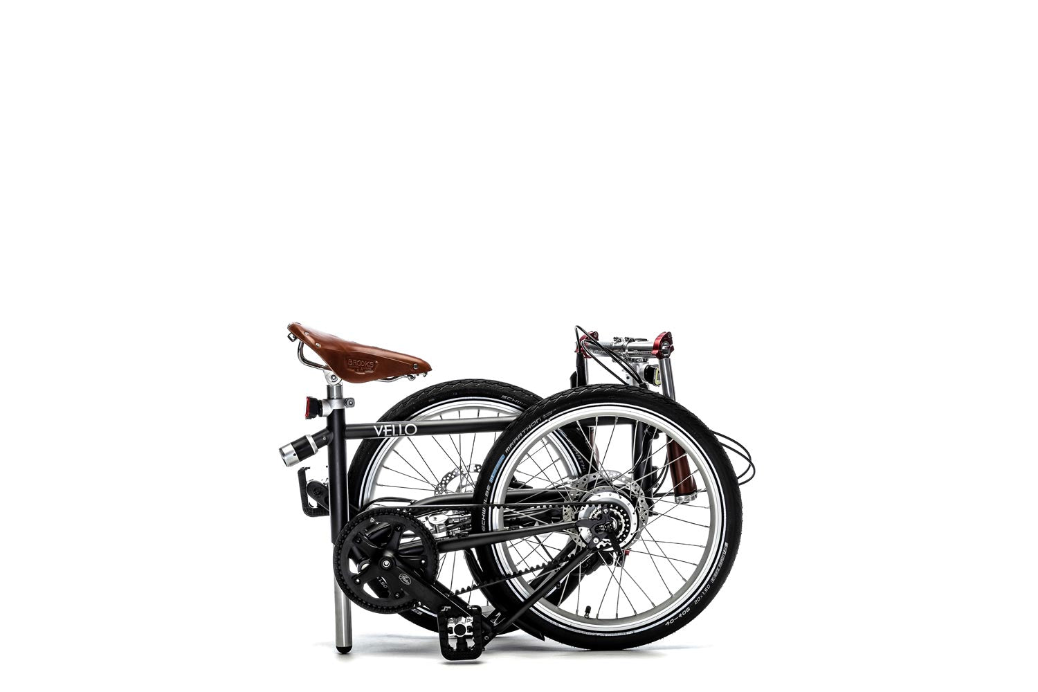 Ein gefaltetes VELLO VELLO Rohloff-Special-Edition Faltrad / Klapprad in der Farbe Anthrazit, mit 20 Zoll Schwalbe Marathon Reifen, mit dem honigbraunen Sattel und faltbaren honigbraunen Lenkern.
