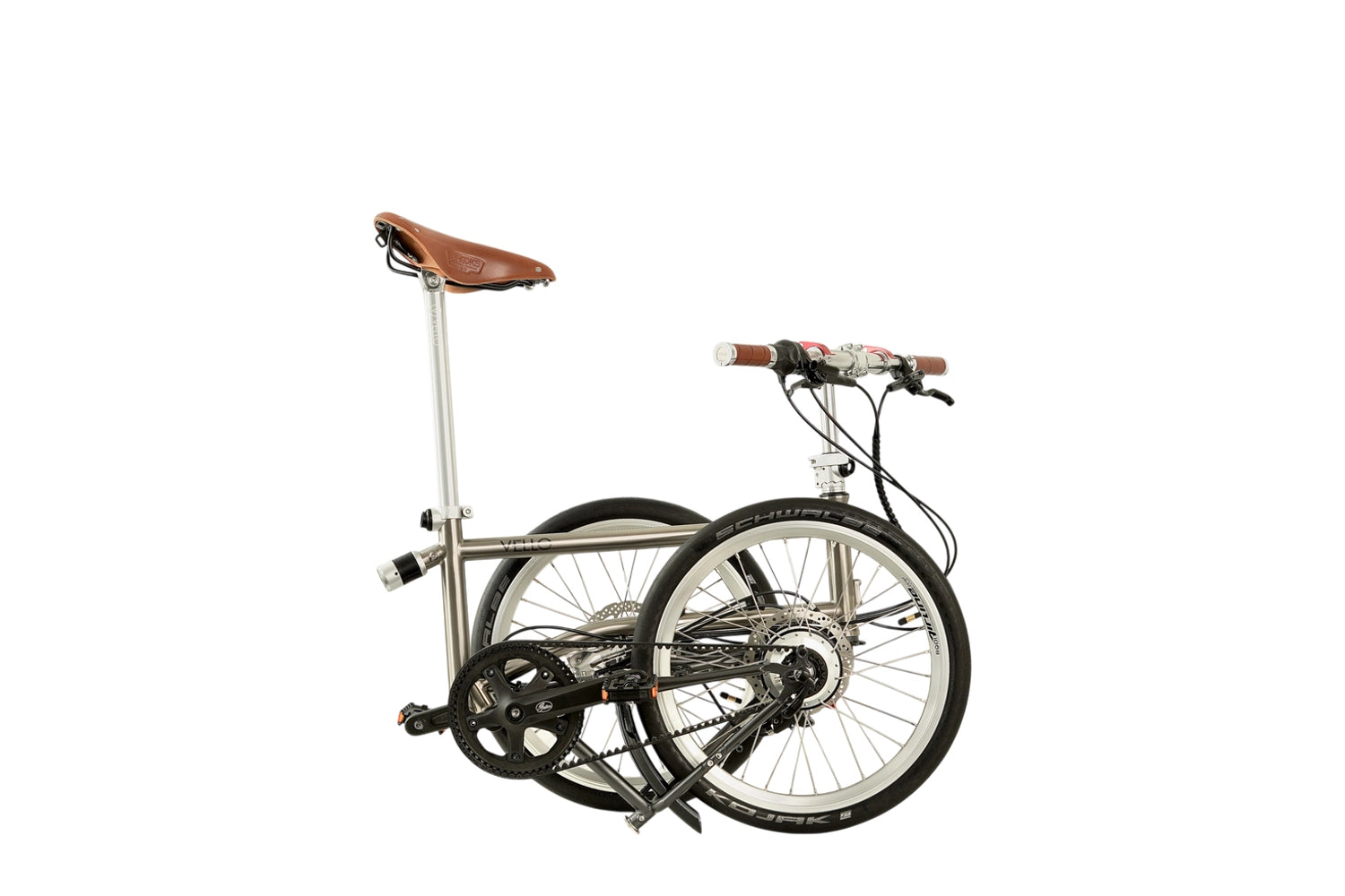 Ein gefaltetes VELLO Rohloff-Special-Edition Faltrad / Klapprad in der Farbe gebürstetes Titan, mit 20 Zoll Schwalbe Kojak Reifen, mit Brooks Sattel in Farbe "honey" und faltbarem Lenker mit Brooks Griffen in Farbe "honey".